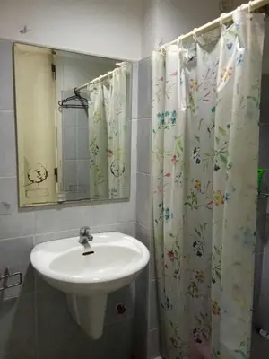 a bathroom with a sink and a shower curtain at David staycation in Manila