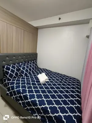 a bedroom with a bed with a blue and white comforter at JAO Cozy Stay - Mall of Asia in Sampong