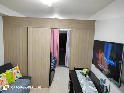a living room with a couch and a flat screen tv at JAO Cozy Stay - Mall of Asia in Sampong