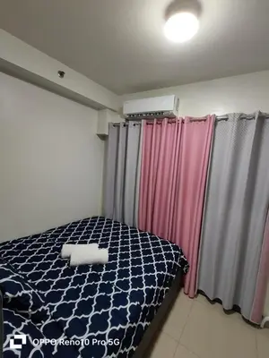 a bedroom with a bed and some curtains at JAO Cozy Stay - Mall of Asia in Sampong