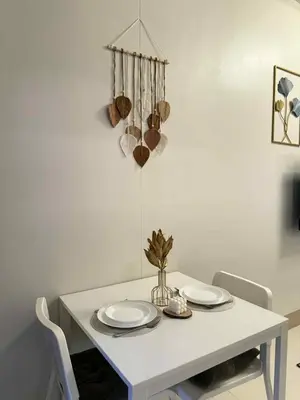 a white dining table with plates and bowls on it at ElcaPri Staycation - Shore 3 Residences in Manila