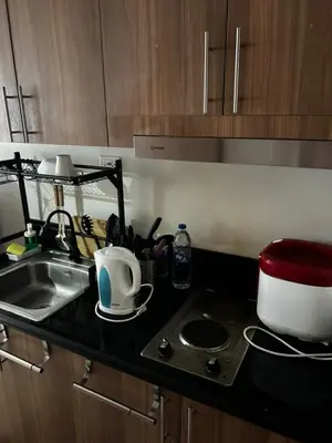 a kitchen counter top with a sink and a stove at Bakshi Lovely Haven 3 in Manila
