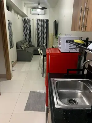 a kitchen and living room with a sink and a microwave at Bakshi Lovely Haven 3 in Manila