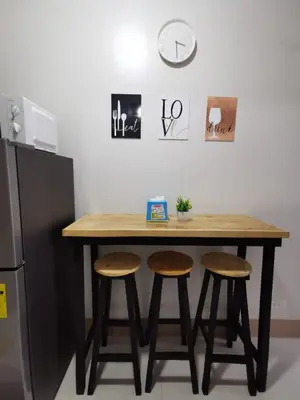 a kitchen table with two stools and a clock on the wall at Mall of Asia condotel shore 3 residence 3 in Manila