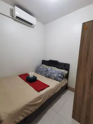 a bedroom with a bed with a black head board at Mall of Asia condotel shore 3 residence 3 in Manila