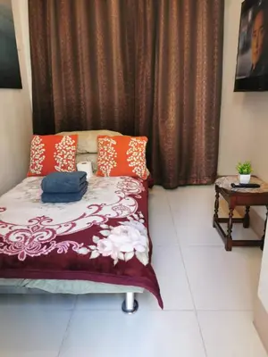 a bedroom with a bed and a table in a room at Mall of Asia condotel shore 3 residence 3 in Manila