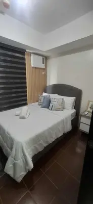 a bedroom with a large bed with white sheets and pillows at House of Lilith at Kasara in Manila
