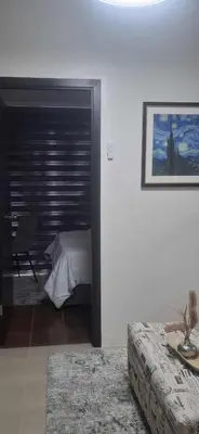 a bedroom with a bed and a table and a couch at House of Lilith at Kasara in Manila