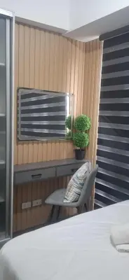 a bedroom with a bed and a chair and a window at House of Lilith at Kasara in Manila