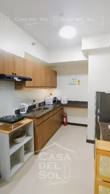 a kitchen with wooden cabinets and a sink at Casa Del Sol Staycation in Manila