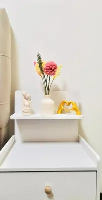 a white shelf with a vase of flowers on it at Casa Del Sol Staycation in Manila