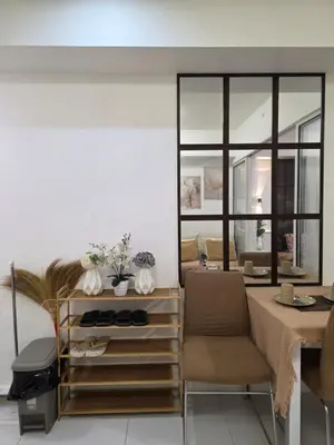 a living room with a table and chairs and a mirror at Casa Serenity Staycation at Azure parañaque with 1 bedroom good for 1 to 4 pax airconditioned room and pool view near sm bicutan in Manila