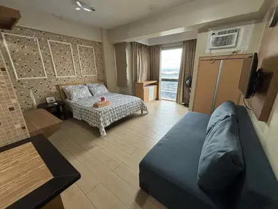 a living room with a bed and a couch at Rqui Rooms Near airport and Newport World Resorts in Manila