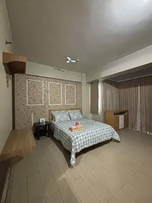 a bedroom with a bed and a table in it at Rqui Rooms Near airport and Newport World Resorts in Manila