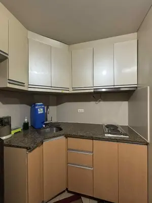a kitchen with white cabinets and a counter top at Rqui Rooms Near airport and Newport World Resorts in Manila