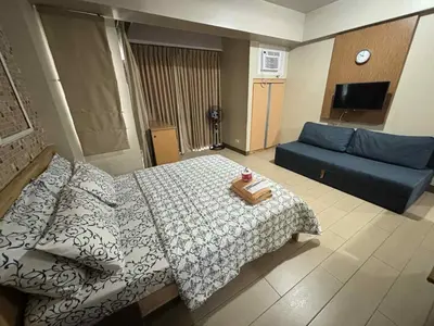 a bedroom with a bed and a blue couch at Rqui Rooms Near airport and Newport World Resorts in Manila
