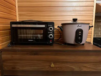 a microwave and a toaster oven on a wooden cabinet at Close dont book in Manila
