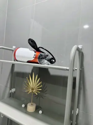 a hair dryer and a comb on a shelf at SMDC AIR Residences in Manila
