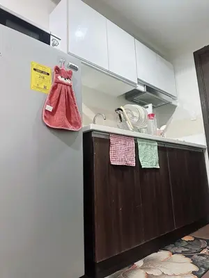 a kitchen with a sink and a red shoe hanging from the wall at SMDC AIR Residences in Manila