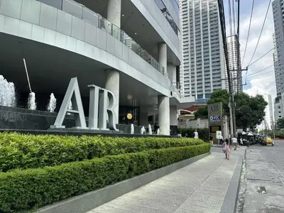 a girl walking down a sidewalk in front of a building at SMDC AIR Residences in Manila