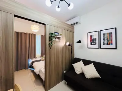 a living room with a couch and a bedroom at 1BR Condotel with Balcony at FAME Residences #FM19-1 in Manila