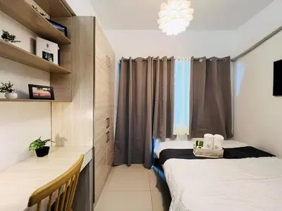 a small room with two beds and a window at 1BR Condotel with Balcony at FAME Residences #FM19-1 in Manila