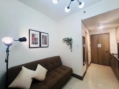 a living room with a brown couch in a room at 1BR Condotel with Balcony at FAME Residences #FM20-1 in Manila