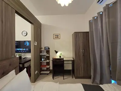 a bedroom with a bed and a desk with a computer at 1BR Condotel with Balcony at FAME Residences #FM21-1 in Manila