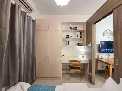 a bedroom with a desk and a table in a room at 1BR Condotel with Balcony at FAME Residences #FM22-1 in Manila