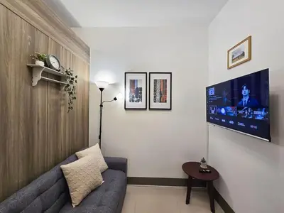 a living room with a couch and a flat screen tv at 1BR Condotel with Balcony at FAME Residences #FM23-1 in Manila