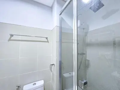 a bathroom with a glass shower and a toilet at 1BR Condotel with Balcony at FAME Residences #FM23-1 in Manila