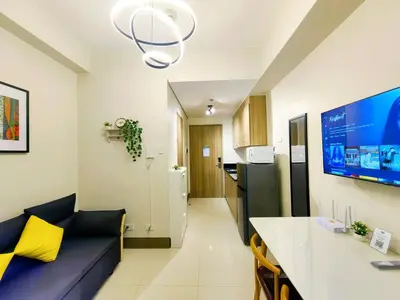 a living room with a couch and a kitchen at 1BR Condotel with Balcony at FAME Residences #FM24-1 in Manila