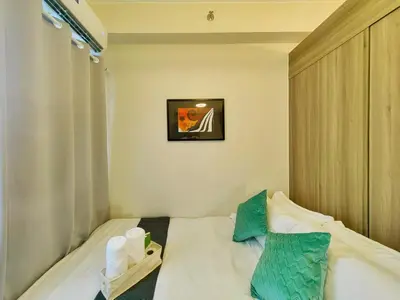 a small bedroom with a bed with two pillows at 1BR Condotel with Balcony at FAME Residences #FM24-1 in Manila