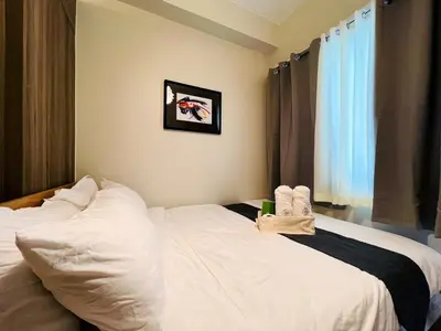 a bedroom with a white bed with towels on it at 1BR Condotel with Balcony at FAME Residences #FM25-1 in Manila