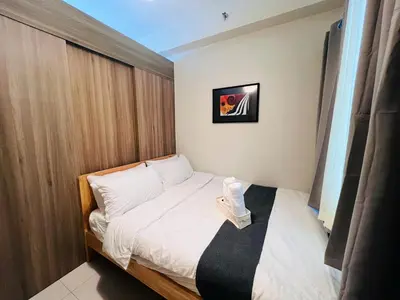 a small bedroom with a bed with white sheets at 1BR Condotel with Balcony at FAME Residences #FM27-1 in Manila