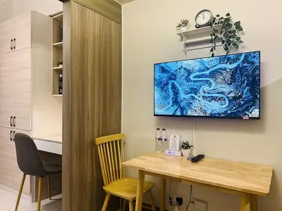 a room with a table and a tv on the wall at 1BR Condotel with Balcony at FAME Residences #FM27-1 in Manila
