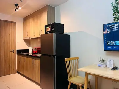 a kitchen with a black refrigerator and a table at 1BR Condotel with Balcony at FAME Residences #FM28-1 in Manila