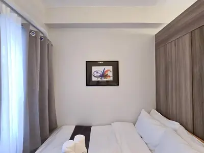 a bed in a room with a picture on the wall at 1BR Condotel with Balcony at FAME Residences #FM30-1 in Manila