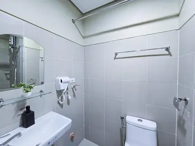 a white bathroom with a toilet and a sink at 1BR Condotel with Balcony at FAME Residences #FM30-1 in Manila