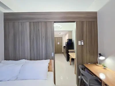 a hotel room with a bed and a desk and a desk at 1BR Condotel with Balcony at FAME Residences #FM30-1 in Manila