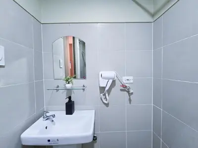 a white bathroom with a sink and a mirror at 1BR Condotel with Balcony at FAME Residences #FM31-1 in Manila
