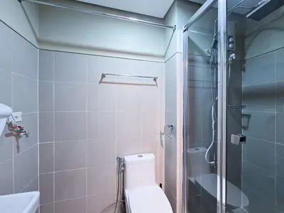 a bathroom with a toilet and a glass shower at 1BR Condotel with Balcony at FAME Residences #FM31-1 in Manila