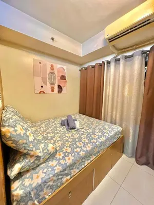 a small bedroom with a bed and curtains at Fika Staycation in Manila