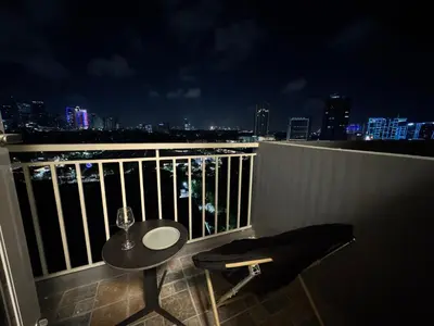 a table and a chair on a balcony at night at Reign Escape in Manila