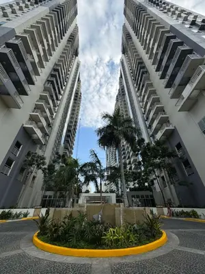 two tall buildings with palm trees in a courtyard at Reign Escape in Manila