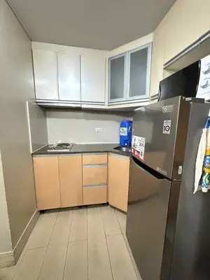 a small kitchen with a refrigerator and cabinets at Rooms Across NAIA Terminal 3 Pasay in Manila