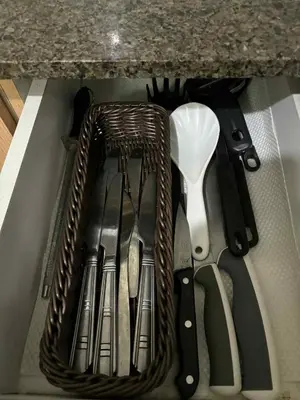 a basket of kitchen utensils sitting in a drawer at Rooms Across NAIA Terminal 3 Pasay in Manila