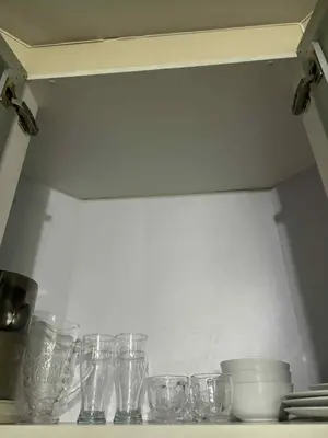 a group of glasses sitting on a shelf in a kitchen at Rooms Across NAIA Terminal 3 Pasay in Manila