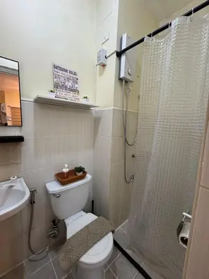 a bathroom with a toilet and a shower and a sink at D88Staycations 104 - Condo near Enchanted Kingdom in Santa Rosa