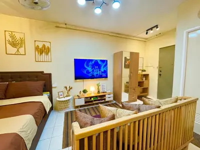 a bedroom with a bed and a living room at D88Staycations 104 - Condo near Enchanted Kingdom in Santa Rosa
